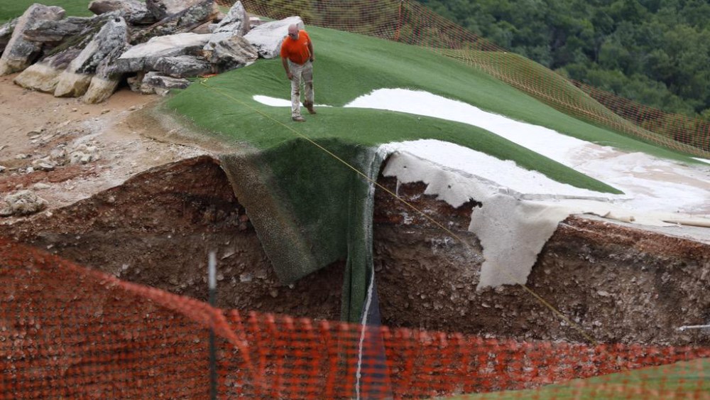 A sinkhole at the Top of the Rock Golf Course in Branson, Mo, May 22, 2015. The 80 feet wide and 35 feet deep hole was created by two separate sinkholes that formed near the entrance to the golf course. (Photo by Nate Papes/Springfield News-Leader/AP)