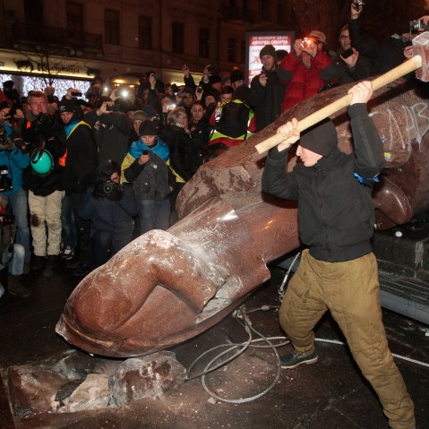 An anti-government protester beats the statue of Vladimir Lenin with a sledgehammer in Kiev, Ukraine on Dec. 8, 2013.