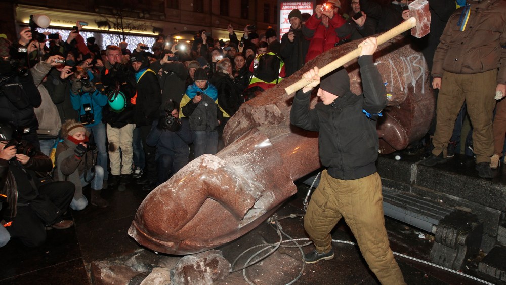 An anti-government protester beats the statue of Vladimir Lenin with a sledgehammer in Kiev, Ukraine on Dec. 8, 2013.