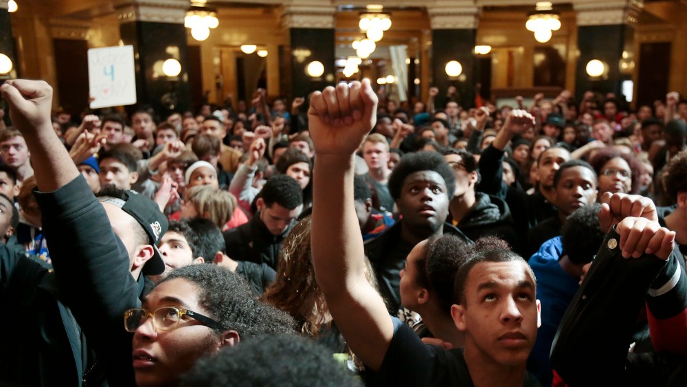 Demonstrators raise their fists to protest the shooting of Tony Robinson at the state Capitol Monday on March 9, 2015, in Madison, Wis. (Photo by Michael P. King/Wisconsin State Journal/AP)