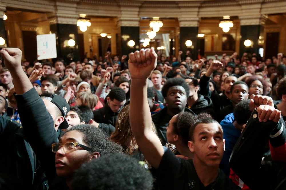 Demonstrators raise their fists to protest the shooting of Tony Robinson at the state Capitol Monday on March 9, 2015, in Madison, Wis. (Photo by Michael P. King/Wisconsin State Journal/AP)