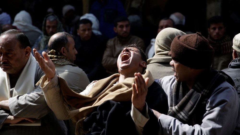 Egyptian Coptic men mourn for 21 Coptic Egyptian men killed by Islamic State militants in Libya, at the Virgin Mary Church in the village of el-Aour, 135 miles south of Cairo, Egypt on Feb. 16, 2015. (Photo by Hassan Ammar/AP)