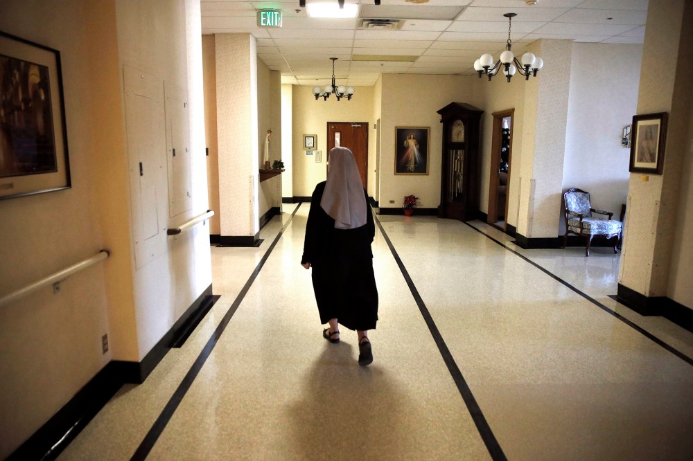 A nun walks in the hallway at the Mullen Home for the Aged, run by Little Sisters of the Poor, in Denver, Colo. (Photo by Brennan Linsley/AP)