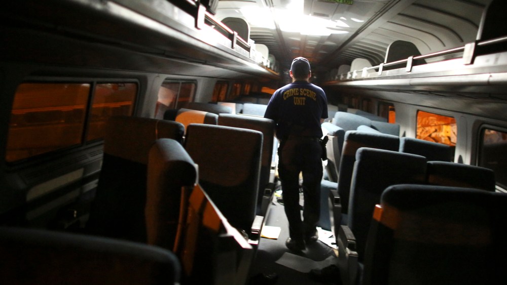 A crime scene investigator looks inside a train car after an Amtrak train wrecked, killing eight people, May 12, 2015, in Philadelphia. (Photo by Joseph Kaczmarek/AP)