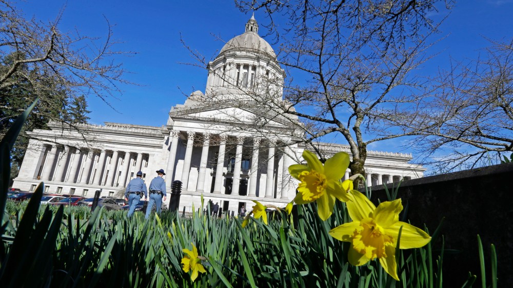 Early daffodils bloom as two Washington State Patrol troopers walk toward the U.S. Capitol, Feb. 17, 2015, in Olympia, Washington. (Photo by Ted S. Warren/AP)