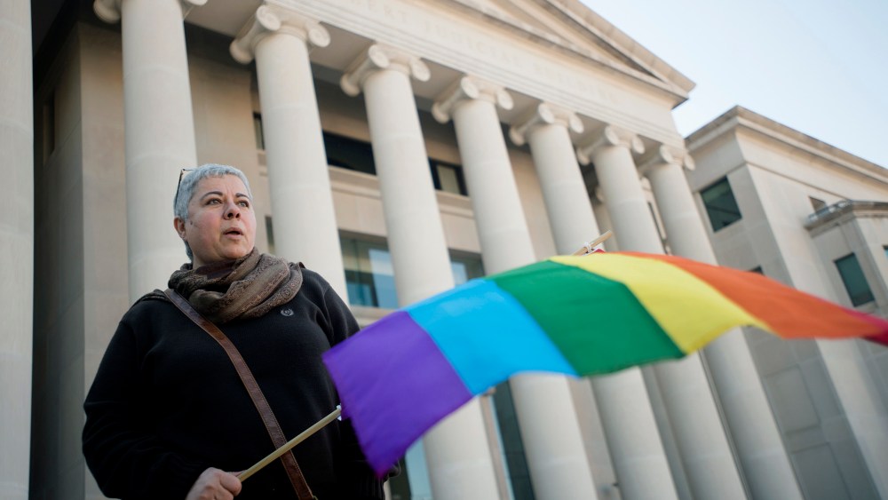 Minoo Vafai holds a rainbow flag during a rally against Alabama Chief Justice Roy Moore, Jan. 12, 2016, outside the Alabama Supreme Court building in Montgomery, Ala. (Photo by Albert Cesare/The Montgomery Advertiser/AP)