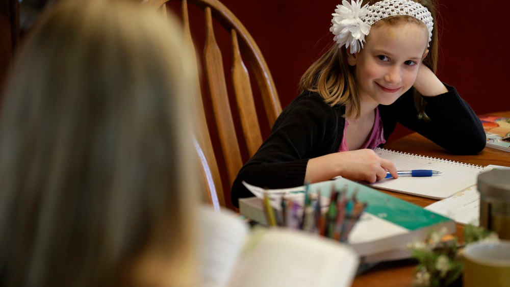 Abigail Gustoff listens to her mom Sara read while home schooling at the kitchen table in in their home in Des Moines, Ia., April 18, 2013. (Photo by Charlie Neibergall/AP)