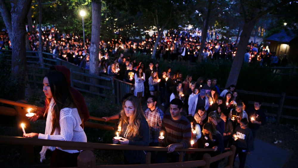 People gather at a park for a candlelight vigil to honor the victims of Friday night's mass shooting on Saturday, May 24, 2014, in Isla Vista, Calif.