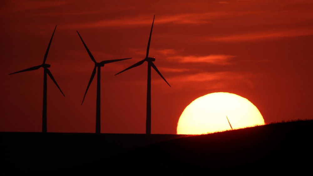 Wind turbines are silhouetted by the setting sun on Aug. 23, 2013, near Beaumont, Kan.