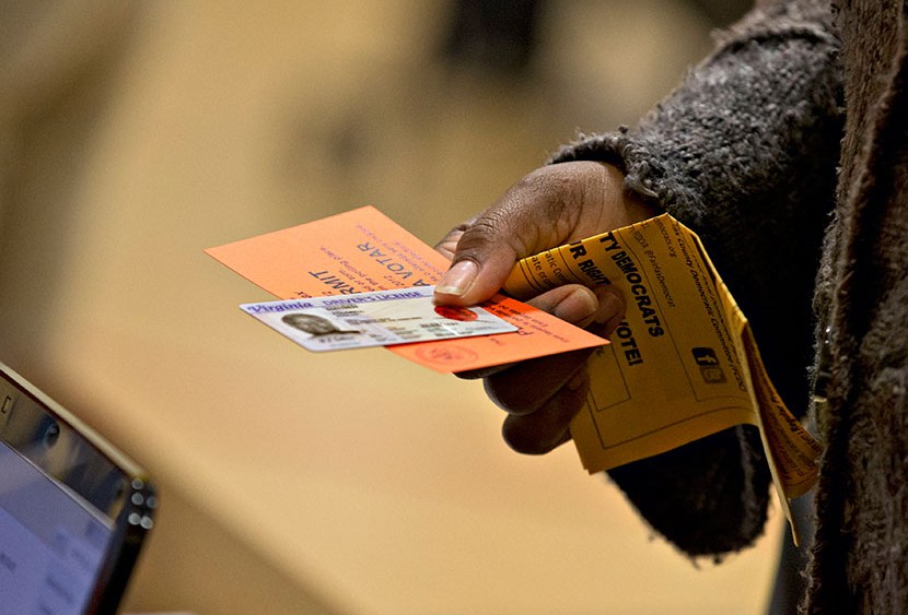 In this Nov. 6, 2012 file photo, a voter holds their voting permit and ID card at the Washington Mill Elementary School near Mount Vernon, Va. Across the South, Republicans are working to take advantage of a new political landscape after a divided U.S....