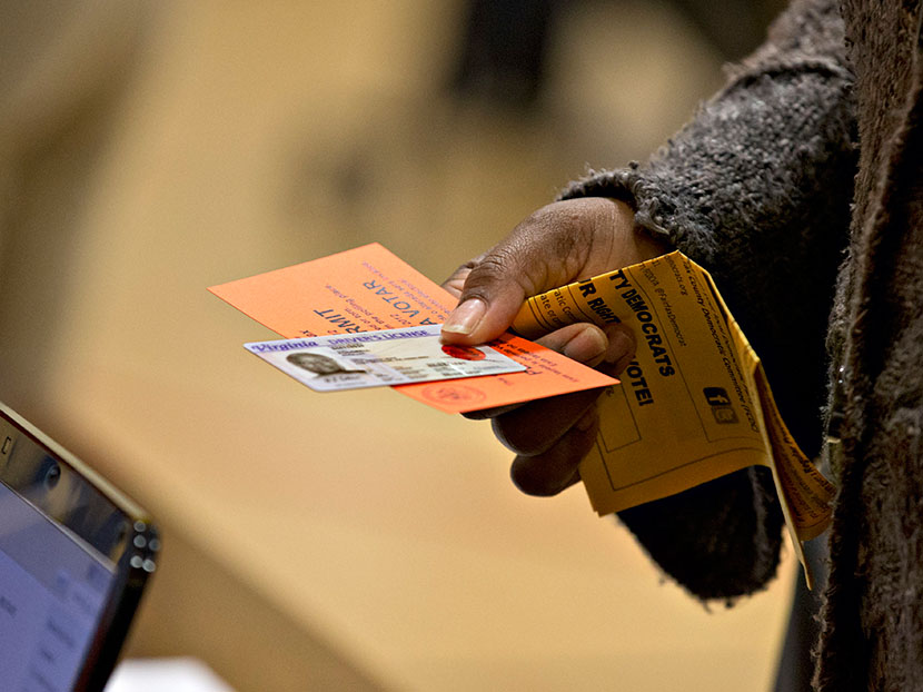 In this Nov. 6, 2012 file photo, a voter holds their voting permit and ID card at the Washington Mill Elementary School near Mount Vernon, Va. Across the South, Republicans are working to take advantage of a new political landscape after a divided U.S....