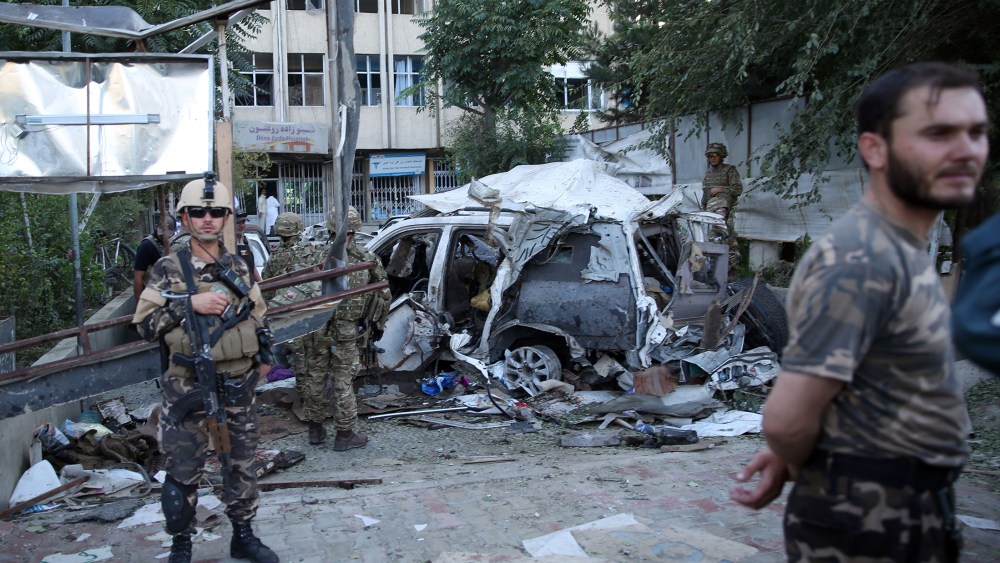 Afghan security forces and British soldiers inspect the site of a suicide attack in Kabul, Afghanistan, Aug. 22, 2015. The bomber attacked a NATO convoy, killing at least 10 people, including three NATO contractors. (Photo by Massoud Hossaini/AP)