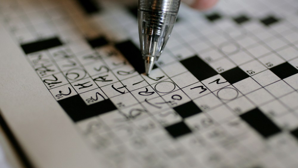 A puzzle fan works on the New York Times crossword puzzle. (Photo by Carolyn Kaster/AP)