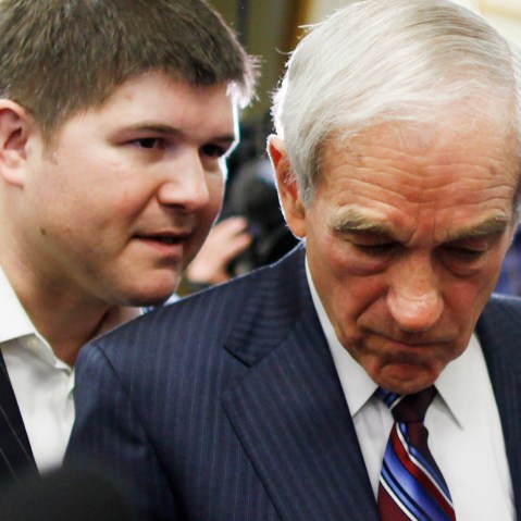 Rep. Ron Paul, R-Texas, listens to campaign chairman Jesse Benton as he signs autographs at the Cass County Community Center in Atlantic, Iowa, Thursday, Dec. 29, 2011. (Photo by Charles Dharapak/AP)