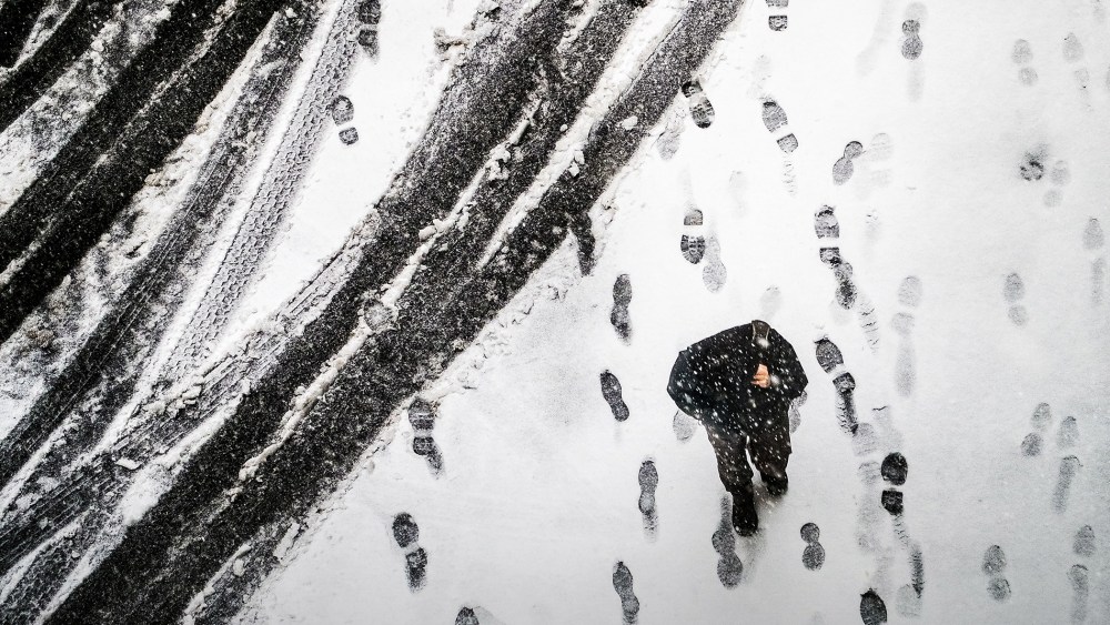 A pedestrian walks through an alley in downtown Washington, March 5, 2015, as snow begins to accumulate. (Photo by J. David Ake/AP)