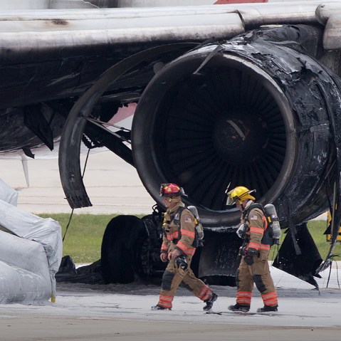 Firefighters walk past a burned out engine of a Dynamic Airways Boeing 767, Oct. 29, 2015, at Fort Lauderdale/Hollywood International Airport in Dania Beach, Fla. (Photo by Wilfredo Lee/AP)
