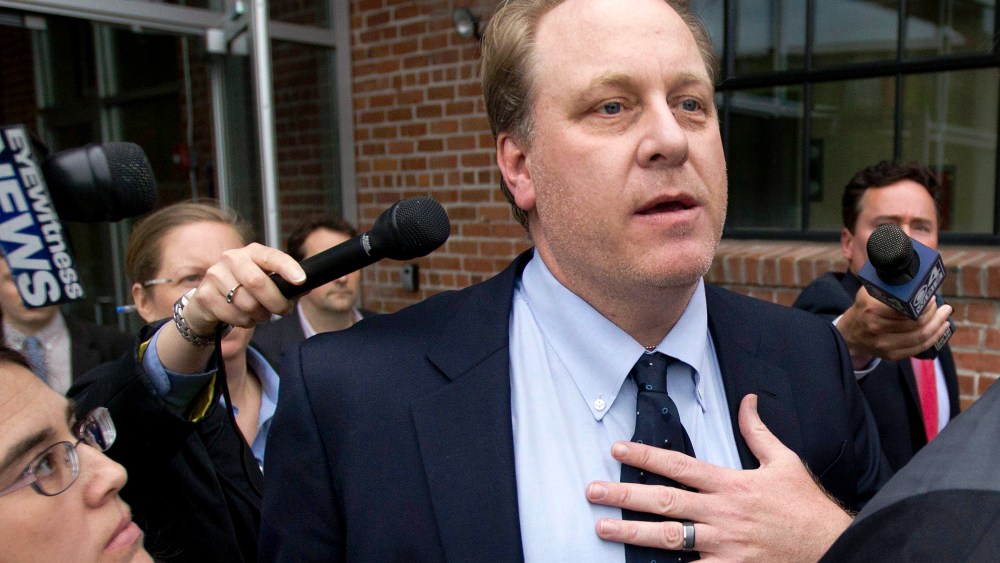 In this May 16, 2012, file photo, former Boston Red Sox pitcher Curt Schilling, center, is followed by members of the media as he departs the Rhode Island Economic Development Corporation headquarters, in Providence, R.I. (Photo by Steven Senne/AP)