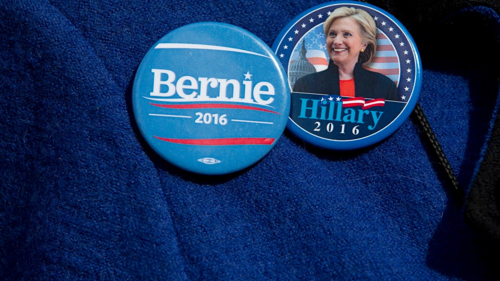 A voter wears buttons for Democratic presidential candidates Sen. Bernie Sanders, I-Vt., and Hillary Clinton buttons, March 31, 2016, in New York. (Photo by Mary Altaffer/AP)