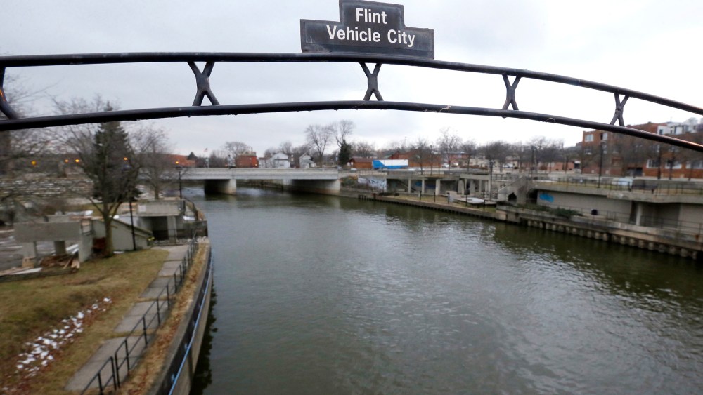 A sign over the Flint River noting Flint, Mich. as Vehicle City on Jan. 26, 2016. (Photo by Carlos Osorio/AP)