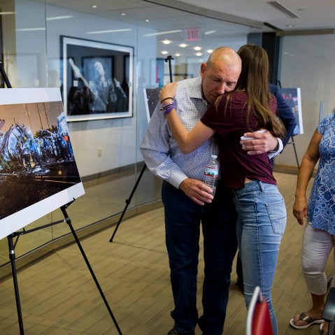 Amtrak crash survivor Robert Hewett embraces his daughter Emily as his wife Judy, right, looks on after a news conference, May 12, 2016, in Philadelphia. (Photo by Matt Rourke/AP)