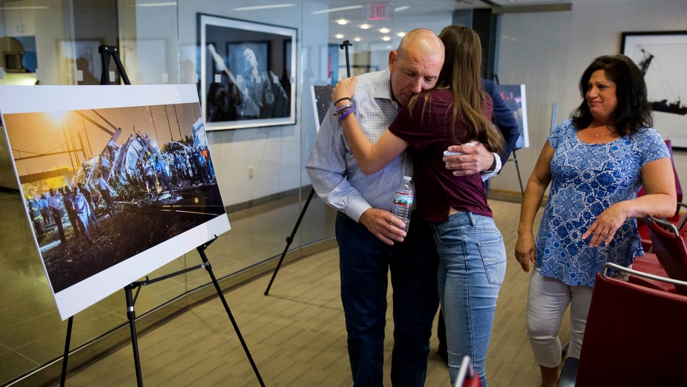 Amtrak crash survivor Robert Hewett embraces his daughter Emily as his wife Judy, right, looks on after a news conference, May 12, 2016, in Philadelphia. (Photo by Matt Rourke/AP)