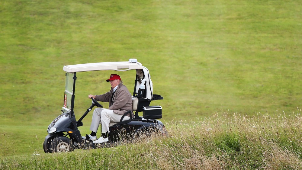 In this July 31, 2015 file photo, Republican presidential candidate Donald Trump drives his golf buggy on the Turnberry golf course in Turnberry, Scotland. (Photo by Scott Heppell/AP)