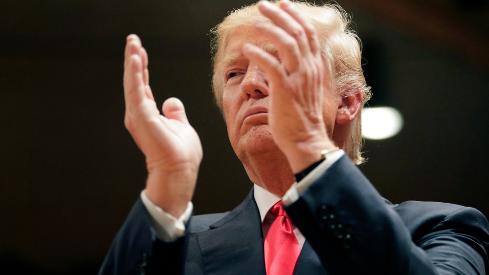 Republican presidential candidate Donald Trump applauds while visiting Saint Francis of Assisi Church, a caucus site on Feb. 1, 2016, in West Des Moines, Iowa. (Photo by Jae C. Hong/AP)