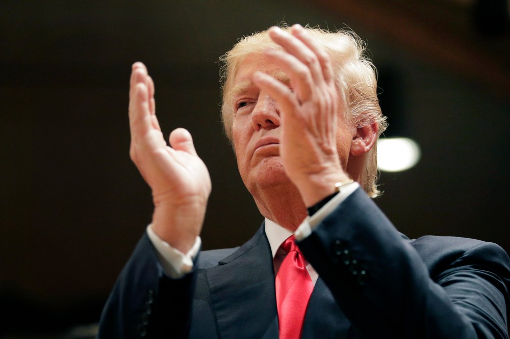 Republican presidential candidate Donald Trump applauds while visiting Saint Francis of Assisi Church, a caucus site on Feb. 1, 2016, in West Des Moines, Iowa. (Photo by Jae C. Hong/AP)