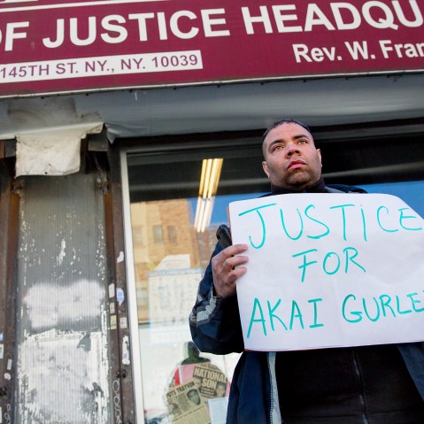 A man stands in front of the National Action Network on Nov. 22, 2014 in N.Y. after Rev. Al Sharpton spoke about the shooting of Akai Gurley. (Photo by Craig Ruttle/AP)