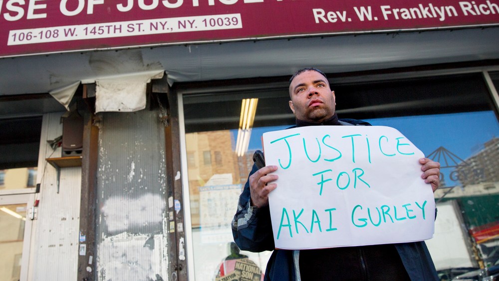 A man stands in front of the National Action Network on Nov. 22, 2014 in N.Y. after Rev. Al Sharpton spoke about the shooting of Akai Gurley. (Photo by Craig Ruttle/AP)