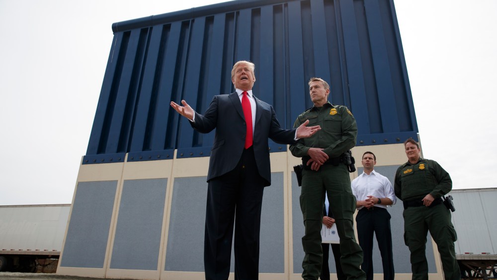 President Donald Trump talks with reporters as he reviews border wall prototypes, Tuesday, March 13, 2018, in San Diego.