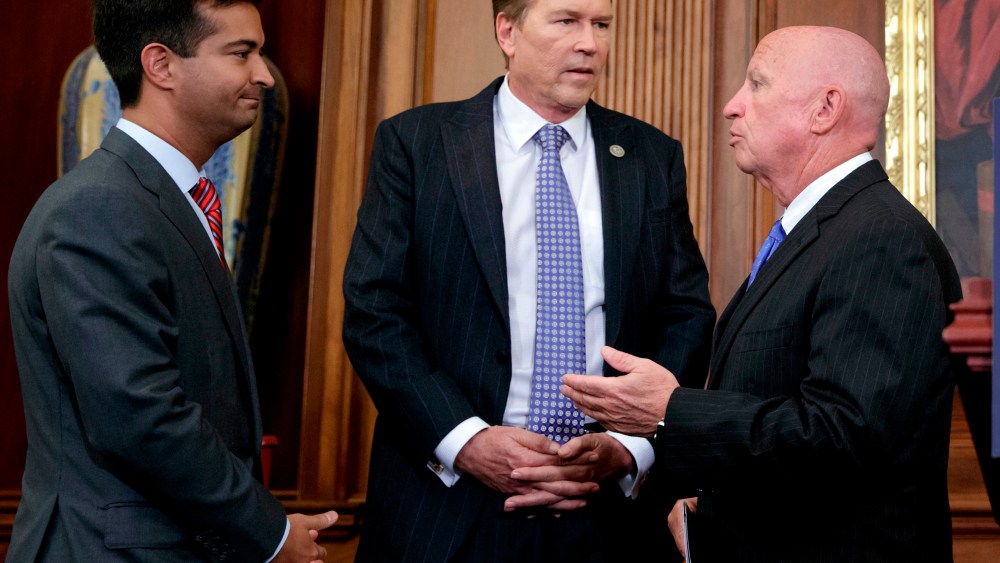 FILE - In this Sept. 27, 2017, file photo, from left, Rep. Carlos Curbelo, R-Fla., Rep. Vern Buchanan, R-Fla., and House Ways and Means Committee Chairman Kevin Brady, R-Texas, confer before a news conference at the Capitol in Washington.
