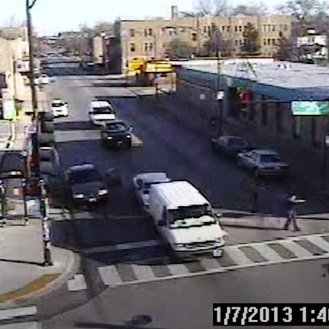 In this image made from a surveillance video, a Chicago police officer is seen aiming his gun at Cedrick Chatman (not pictured), on Jan. 7, 2013, in Chicago. (Photo by City of Chicago Law Department/AP)