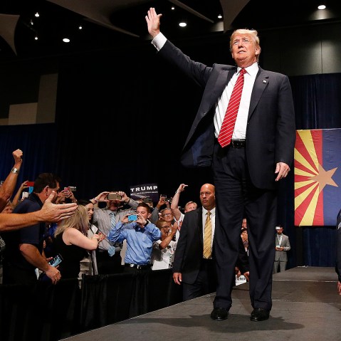 Republican presidential candidate Donald Trump waves to the crowd as he arrives to speak at a rally before a crowd of 3,500, July 11, 2015, in Phoenix. (Photo by Ross D. Franklin/AP)