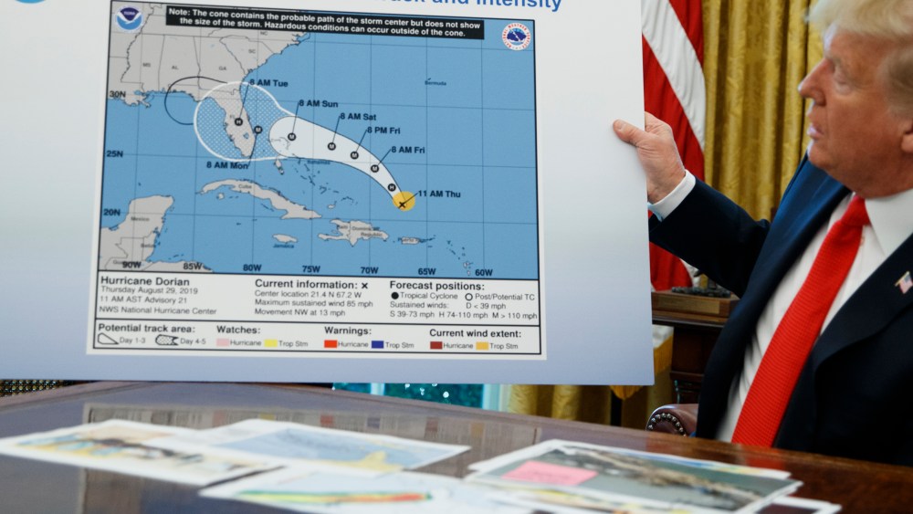 President Donald Trump holds a chart as he talks with reporters after receiving a briefing on Hurricane Dorian in the Oval Office of the White House, Wednesday, Sept. 4, 2019, in Washington.