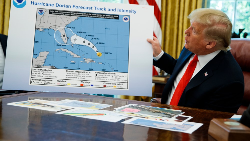 President Donald Trump holds a chart as he talks with reporters after receiving a briefing on Hurricane Dorian in the Oval Office of the White House, Wednesday, Sept. 4, 2019, in Washington.