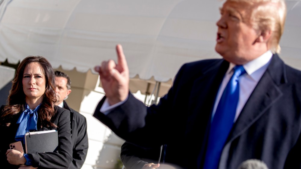 White House press secretary Stephanie Grisham, left, listens as President Donald Trump speaks to reporters on the South Lawn of the White House in Washington, Friday, Nov. 8, 2019.