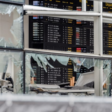 An arrivals and departure board is seen behind blown out windows at Zaventem Airport in Brussels on March 23, 2016. (Photo by Geert Vanden Wijngaert/AP)