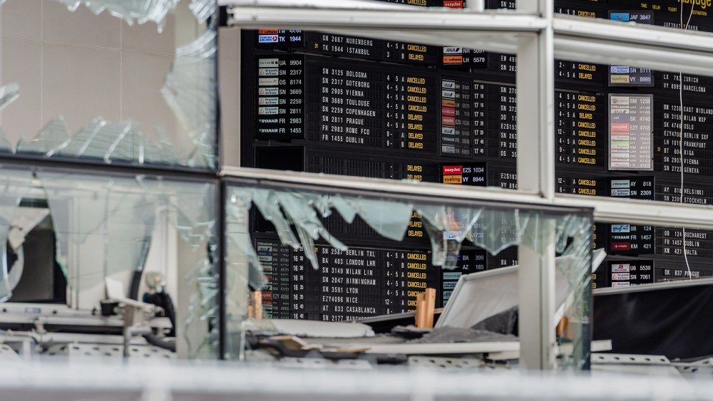 An arrivals and departure board is seen behind blown out windows at Zaventem Airport in Brussels on March 23, 2016. (Photo by Geert Vanden Wijngaert/AP)