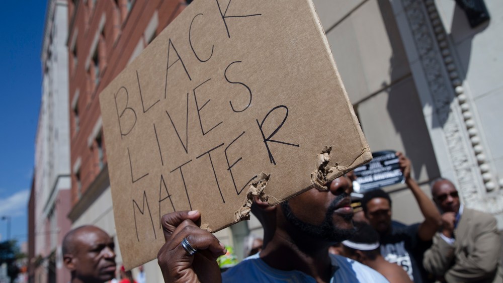 Demonstrators hold signs outside the office of Hamilton County prosecutor Joe Deters' office during a protest demanding release of video showing the shooting death of Samuel Dubose on July 23, 2015, in Cincinnatti, Ohio. (Photo by John Minchillo/AP)