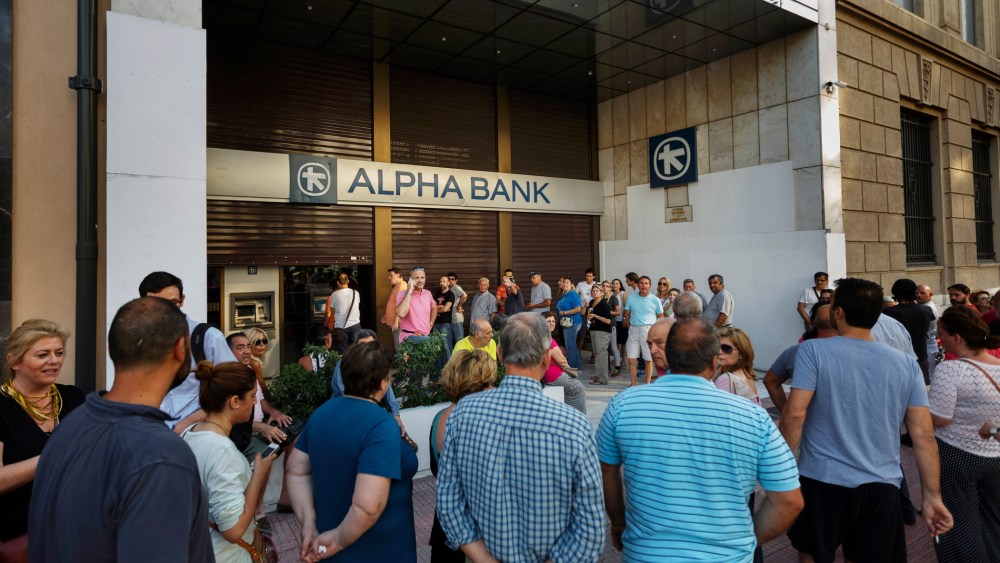 People stand in a queue to use ATM cash machine of a bank in central Athens on June 28, 2015. (Photo by Daniel Ochoa de Olza/AP)