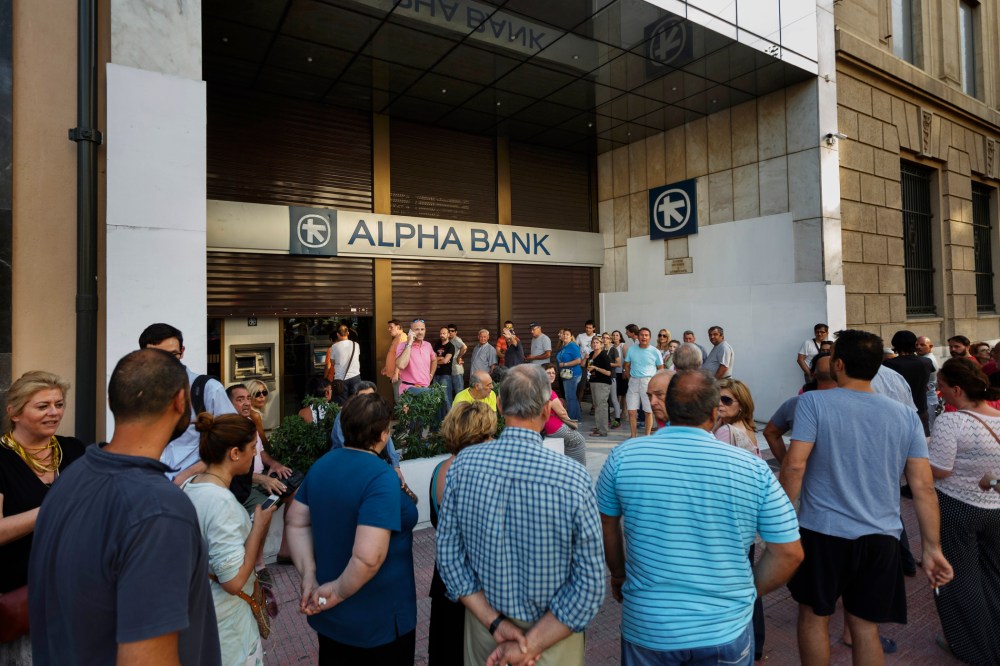 People stand in a queue to use ATM cash machine of a bank in central Athens on June 28, 2015. (Photo by Daniel Ochoa de Olza/AP)