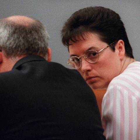 Kelly Gissendaner peers over the shoulder of one of her lawyers, Ed Wilson, during her murder trial in Lawrenceville, Ga., Nov. 13, 1998 (Photo by Louie Favorite/Atlanta Journal-Constitution/AP)