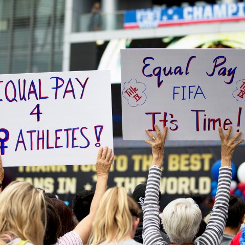 Two women hold up signs demanding equal pay for female athletes during a public rally held to celebrate the U.S. women's soccer team's World Cup championship on July 7, 2015, in Los Angeles, Calif. (Photo by Jae C. Hong/AP)