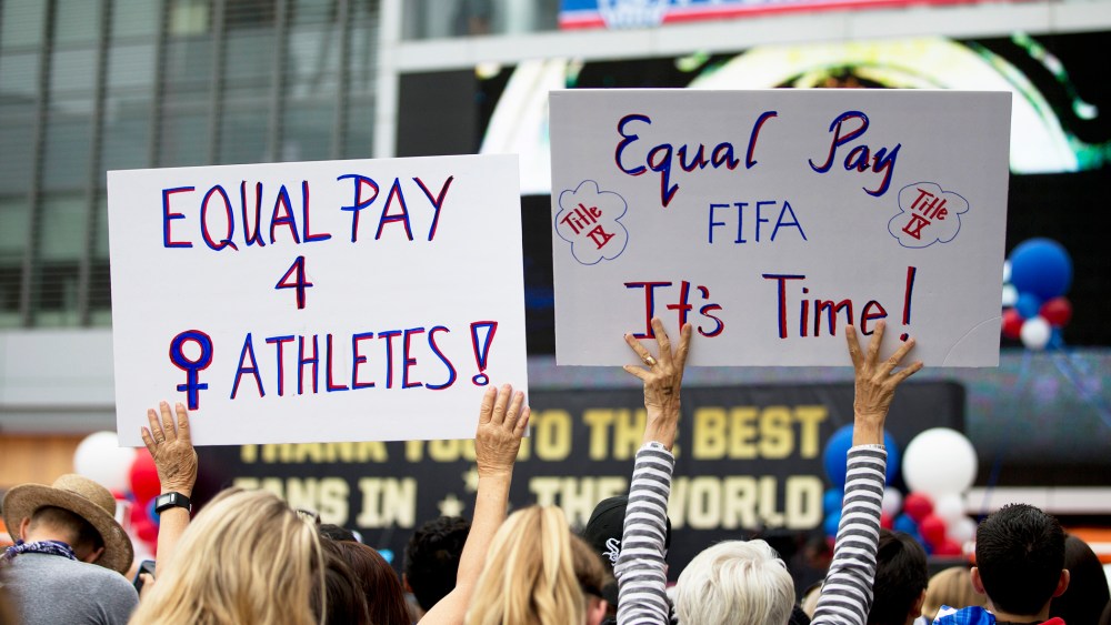 Two women hold up signs demanding equal pay for female athletes during a public rally held to celebrate the U.S. women's soccer team's World Cup championship on July 7, 2015, in Los Angeles, Calif. (Photo by Jae C. Hong/AP)