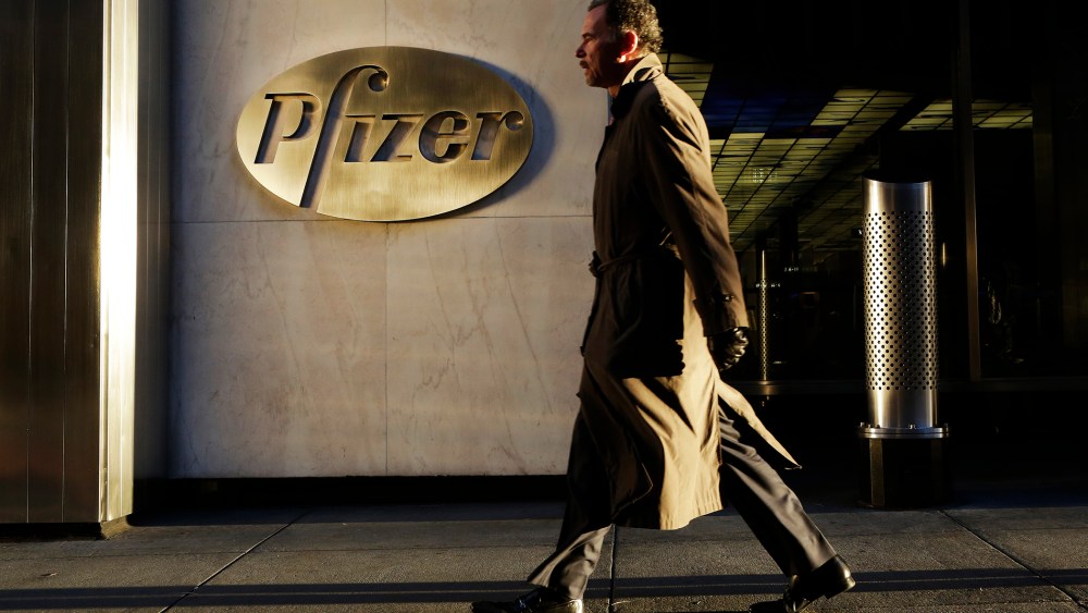 A man walks past Pfizer World Headquarters, Nov. 23, 2015 in New York. (Photo by Mark Lennihan/AP)
