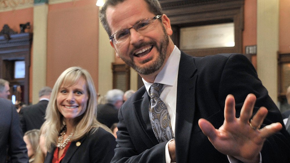 In this Jan. 14, 2015 photo, Rep. Cindy Gamrat, R-Plainwell, and Rep Todd Courser, R-Lapeer wave to reporters in the House of Representatives in Lansing. (Photo by Dale G. Young/Detroit News/AP)