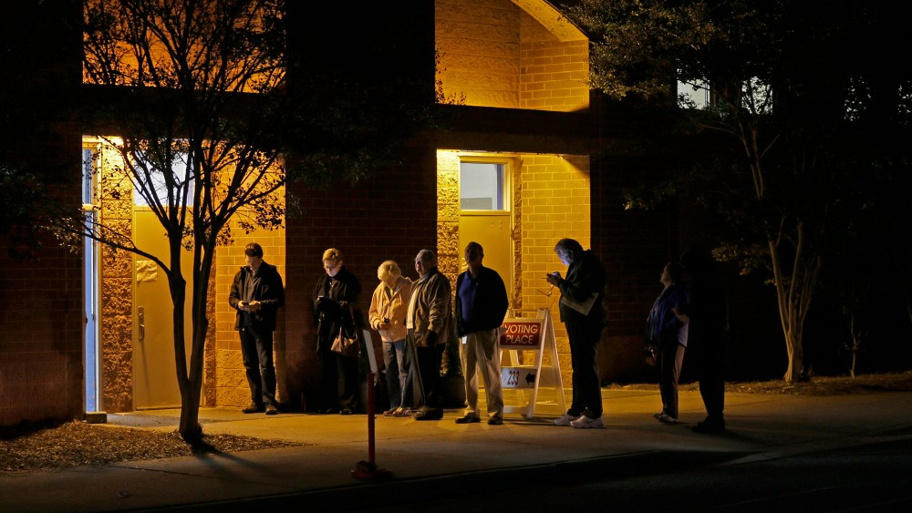 A handful of people wait in line before the polling place at Elizabeth Lane Elementary school opens for voting in Matthews, N.C., Nov. 4, 2014. (Photo by Chuck Burton/AP)