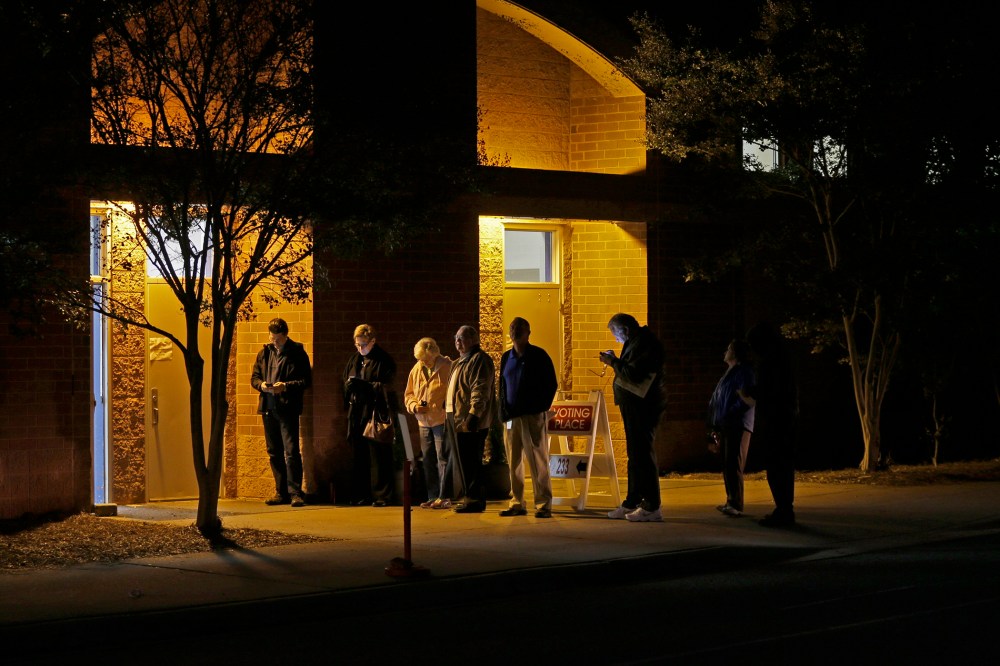 A handful of people wait in line before the polling place at Elizabeth Lane Elementary school opens for voting in Matthews, N.C., Nov. 4, 2014. (Photo by Chuck Burton/AP)