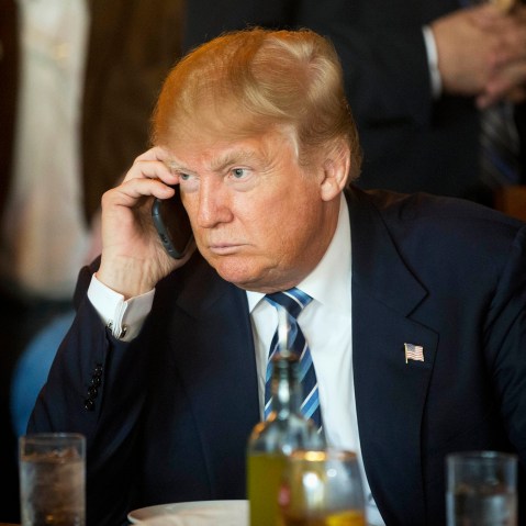 Republican presidential candidate Donald Trump listens to his mobile phone during a lunch stop, Feb. 18, 2016, in North Charleston, S.C. (Photo by Matt Rourke/AP)
